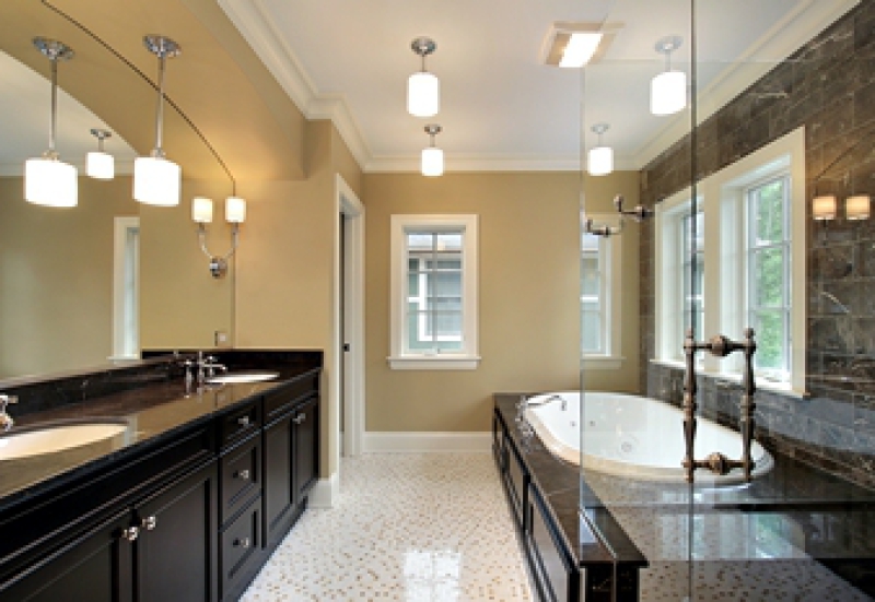 Remodeled bathroom with platform bathtub and dark cabinetry with two sinks